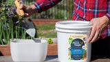 Transferring soluble plant food from a bucket into a plant pot